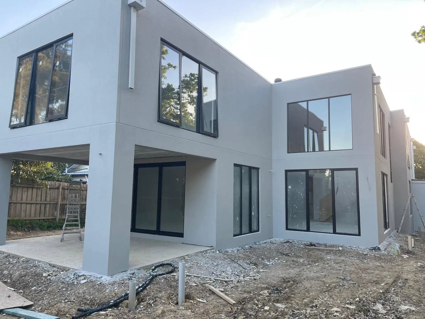 Rear corner of the Mont Albert home with big black-framed windows and clean render lines