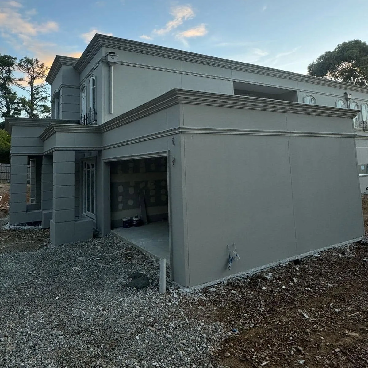 Side and garage elevation of a new home with square-set render bands